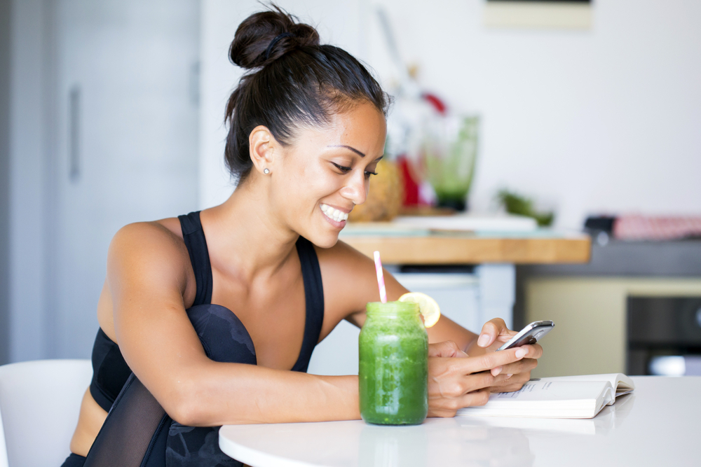 Fitness woman drinking a healthy green smoothie juice for a detox